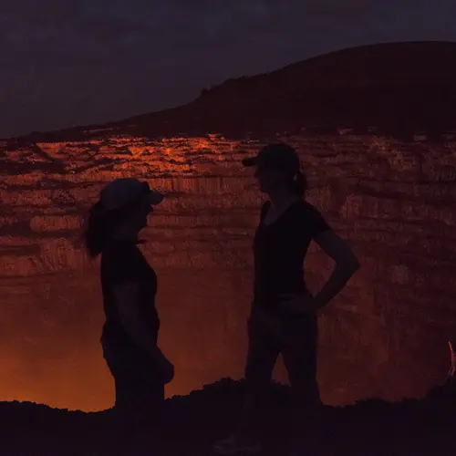 Lara and Diana Silhouetted against the glow of lava